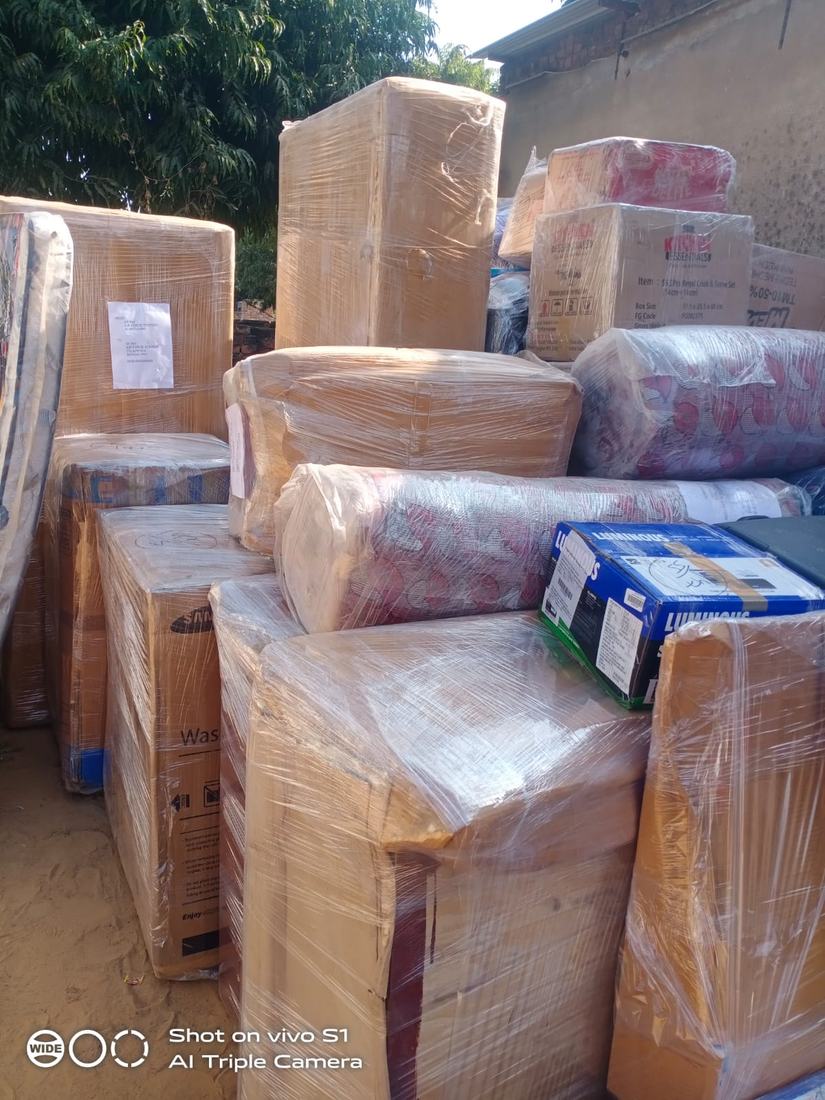 Furniture and appliances wrapped and stacked outside a home
