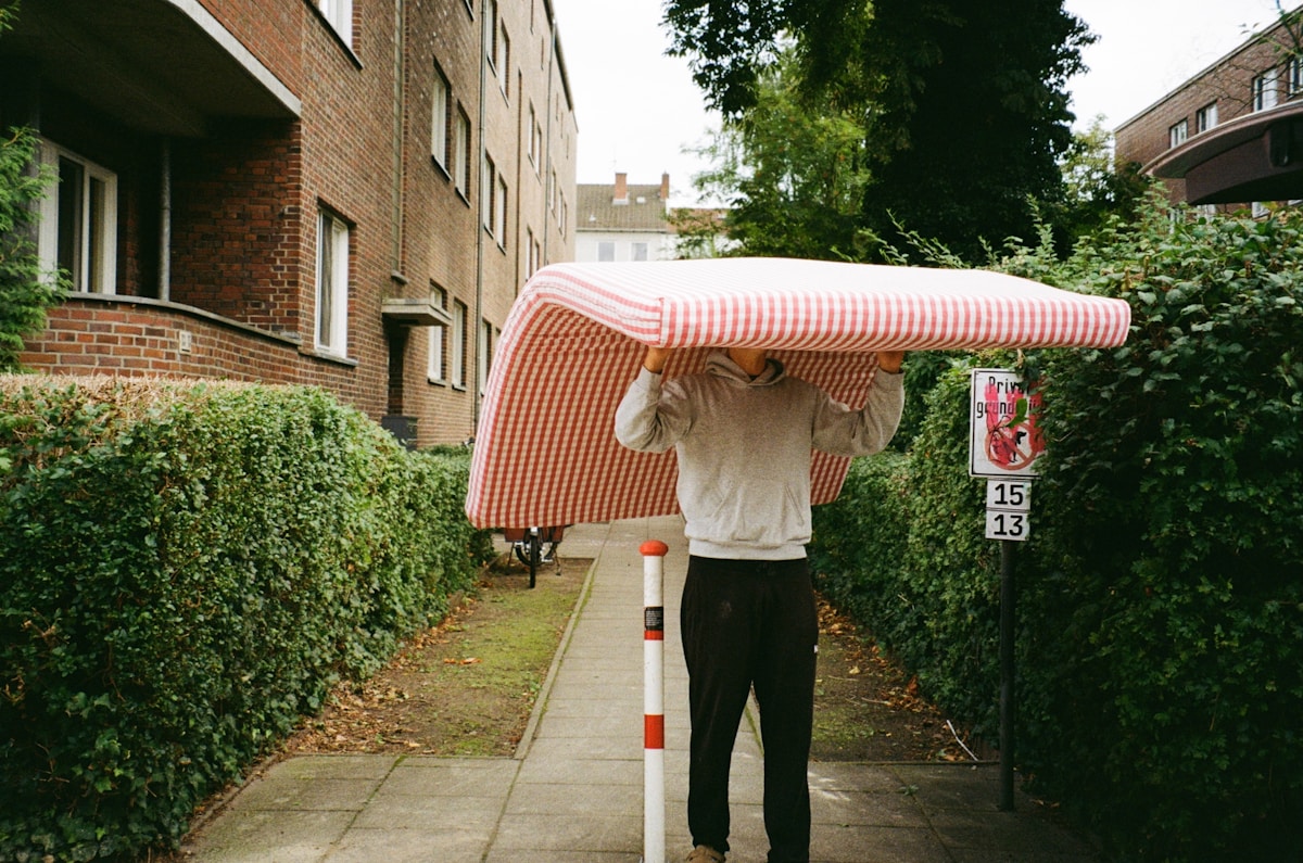 Mover carrying a wrapped mattress during a household move